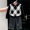 Ropa infantil coreana 2026 colección de otoño nueva: suéter clásico negro con patrón de rombos y cuello, y pantalón de traje gris recto para niños