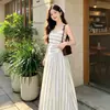 Vestido listrado estilo férias de verão, vestido longo sem mangas, perfeito para sessões de fotos, criando um look de praia suave e romântico.