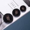 Nuevo patrón de resina botón de cuatro ojos abrigo de lana redondo cortavientos botón de abrigo botón de traje fabricante en stock