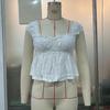 Fuente transfronteriza de blusa corta con encaje floral y cuello hueco con tirantes para mujer europea y americana elegante SU3897