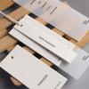 Logotipo para hacer etiquetas de ropa, tarjeta blanca de arroz espesado, diseño para colgar ropa, marca registrada para hombres y mujeres, elevador general, disponible en stock