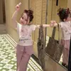 Conjunto de verano nuevo estilo coreano para niñas 2026, camiseta linda para bebés, top versátil, pantalones de pierna ancha con dobladillo de volantes a la moda