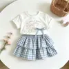 Nuevo conjunto de verano para niñas estilo coreano, elegante y versátil, de manga corta con dibujos animados, dulce y lindo conjunto de dos piezas a cuadros estilo coreano, moderno