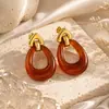 Aretes de acero de titanio transfronterizos Yuhui, con un diseño geométrico hueco de resina de color ámbar estilo Melard, aretes de acero inoxidable
