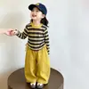 Conjunto amarillo de camiseta a rayas con cintura ceñida para niña estilo coreano, nuevo modelo primavera y otoño 2026, elegante conjunto de dos piezas para niñas pequeñas