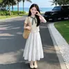 Conjunto de Dos Piezas para Niña de Verano Nueva Moda Camiseta de Manga Corta a Cuadros con Parches Falda Dulce Linda con Moño