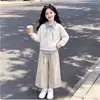Conjunto de moda primavera e outono para meninas: um top estiloso com lapela e design patchwork, criando um visual de duas peças falsas, combinado com calças casuais versáteis e da moda - um conjunto de duas peças