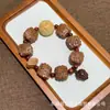 El fabricante suministra una colección de pulseras de hueso de durazno naturales, pulseras de hueso de durazno de círculo único para hombres y mujeres, populares en Xiaohongshu, con diseño de agujero pasante