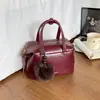 2026 Nuevo Bolso Almohada Boston Estilo Maillard para Mujer Bolso de Mano Retro Bolso de Hombro Cruzado Decoración de Bola de Pelo para Viajes Diarios