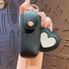 Bolsa de almacenamiento de cuero para lápiz labial linda, simple y portátil, llavero, mini espejo de maquillaje en forma de corazón, colgante para bolso de niña