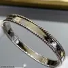 Este Pulsera de Cuentas de Trébol de Cuatro Hojas en Oro Rosa de 18 Quilates con Bordes de Cuentas de Calidoscopio y Diseño de Firma para Mujer