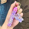 Llavero Colgante Oso Sentado Luminoso de Acrílico Relleno de Aceite Llavero de Máquina de Garra Encanto para Bolso Pequeño Regalo Venta al por Mayor
