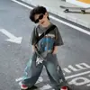 Conjunto Infantil Masculino Verão Novo 2026 Estilo Coreano Estampado Manga Curta Solto Fashionável Jeans Lindo Conjunto de Duas Peças