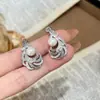 Exquisitos aretes de perla con pluma de plata microincrustada para mujer, estilo vintage de nicho de lujo ligero de alta gama, joyería de anillo versátil