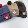 Chapéu de tricô com patch de urso de desenho animado estilo coreano para crianças, chapéu de tricô com punho em blocos de cor e pompom, chapéu quente de outono e inverno para bebê