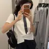 Camiseta minimalista de manga corta estilo coreano para mujer con diseño retorcido, blanca, dobladillo asimétrico, corte ajustado, top cropped de moda