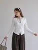 Camiseta negra de manga larga con cuello en V y decoración de botones para mujer, nuevo estilo otoño 2026, abertura irregular, top entallador