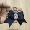 Lazo Negro de Satén Tejido a Mano Anillo de Resorte Metálico Broche Colgante Decorativo para Bolsos y Zapatos DIY