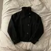 Jaqueta curta de lã preta, simples e elegante, com gola alta de pé, fechamento diagonal por botões e punhos dobrados.