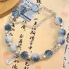 Livro de equitação vermelho explosivo azul e branco cor de porcelana combinando antiga borboleta Tassel pulseira de nicho feminino design estilo chinês ping an fu marca