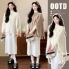 Nueva ropa de maternidad de otoño e invierno: un conjunto de dos piezas que presenta un cárdigan de punto con detalles trenzados y flecos, combinado con un vestido de punto que cubre el vientre y crea un efecto adelgazante