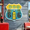 Arte de parede feita sob medida em folha de flandres com design de escudo estilo Western, retratando a Rota 66 e um galpão de locomotiva vintage, para uma decoração de parede nostálgica