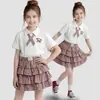 Conjunto de dos piezas de estilo universitario coreano para niñas con falda corta de cuadros, camiseta de manga corta de dibujos animados de verano y falda de pastel para niños mayores