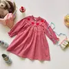 Coleção Outono 2026 Roupas Infantis Bordado de Maçã Manga Longa Vestido para Meninas Gola Alta Mangas Bufantes Estilo Coreano Saia Xadrez Infantil Tendência