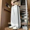 Pantalones casuales rectos para hombre, pantalones de pierna ancha holgados de moda para otoño con tres rayas, versátiles para adolescentes, adecuados para deportes