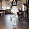Nueva colección Primavera/Verano 2026: Vestido corto negro para mujer, con un diseño de falda acampanada inspirado en el ballet, silueta en A, cintura alta y un bajo escalonado tipo pastel.
