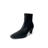 Botas finas minimalistas e elegantes de estilo coreano combinadas com uma saia, coleção outono/inverno 2026, apresentando um pequeno salto bloco, salto médio, bico quadrado e material elástico, adequadas para o trabalho e o uso diário