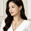 Pendientes y Collar Bohemios Europeos y Americanos con Borlas de Estrella Solar Ráfaga Oro Envejecido Retro Accesorios de Vacaciones de Nicho