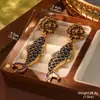Estilo de corte europeo y americano oro ruso nicho nuevos aretes medievales borla perla diseño ojo de tigre aretes de alta gama