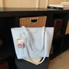 Bolso tote moderno y práctico de gran capacidad con un diseño de dibujos animados en relieve, un nuevo y elegante bolso de hombro y un bolso tipo cubo adecuado para estudiantes universitarios.