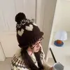 Atacado 25 Anos Outono e Inverno Novo Chapéu de Tricô Jacquard Coração Doce com Pom-Pom Proteção Quente para Orelhas Afina o Rosto Gorro Moderno