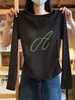Camiseta feminina de gola V, manga longa, corte slim, acinturada, na cor cáqui, feita de algodão puro, projetada para valorizar a silhueta, para o outono de 2026