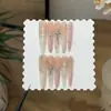 Um Conjunto de Unhas com um Gradiente Âmbar Ligeiramente Bêbado, Pó Branco Leitoso, Estilo Francês e Pedrinhas de Coração Cromadas