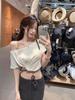 Camiseta Branca Off-Shoulder de Manga Curta para Mulheres no Verão com Nó Torcido Design Slim Nicho Look Emagrecedor Top Cropped Curto