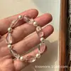 El pulsera de cristal blanco de diseño fresco y elegante de Chenmo ofrece un lujo ligero y una sensación de alta gama, un accesorio de mano de cuentas de nicho para mujeres que se vende en puestos