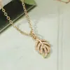 Aogu Niche Lujo Accesible Chapado en Cobre Oro de 18 Quilates Zirconia Colgante Pluma Hoja Collar Moda para Mujer Cadena de Clavícula de Gama Alta Nuevo