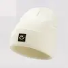 Nuevo Gorro de Punto con Cara Sonriente Transfronterizo con Etiqueta de Cuero, Gorro de Punto Unisex para Otoño e Invierno, Disponible en Stock Color Sólido, Hace que la Cara Parezca Más Pequeña