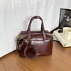 2026 Nuevo Bolso Almohada Boston Estilo Maillard para Mujer Bolso de Mano Retro Bolso de Hombro Cruzado Decoración de Bola de Pelo para Viajes Diarios