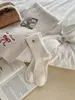 Calcetines de nube de terciopelo blanco leche para mujer, calcetines retro de rayas verticales de color liso con botón de nácar, calcetines de media pantorrilla, calcetines de felpa Maillard para otoño e invierno
