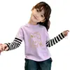 Camiseta de manga larga de algodón puro para niña 2026 primavera y otoño nueva con estampado de dibujos animados lindos cuello redondo patchwork a rayas top