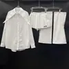Nuevo conjunto de tres piezas de otoño de 2026 para mujer: camisa de corte ancho, blusa holgada y versátil + falda + calentadores de piernas