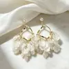 Pendientes de clip para oreja sin perforación con borla de pétalo de concha francesa súper etéreos para mujer, pendientes de botón de zirconia de alta gama elegantes y lujosos