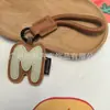 Venta al por mayor transfronteriza de llaveros japoneses y coreanos con letras en inglés, dijes para bolso de cuero dopamina, pequeños accesorios y regalos