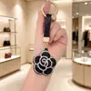 Bestseller transfronterizo creativo colgante llavero rosa incrustado de diamantes accesorio de bolso flor de strass de cuero regalo decoración