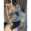 Además, la nueva moda de otoño presenta un elegante conjunto de dos piezas: una camisola de cuello halter en U con botones de concha y un cárdigan de punto MQ1709