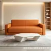 Sofá minimalista de cuero negro de tres plazas, adecuado tanto para uso en la sala de estar como para la relajación, con reposabrazos anchos y cómodos y acolchado de alta resistencia.
